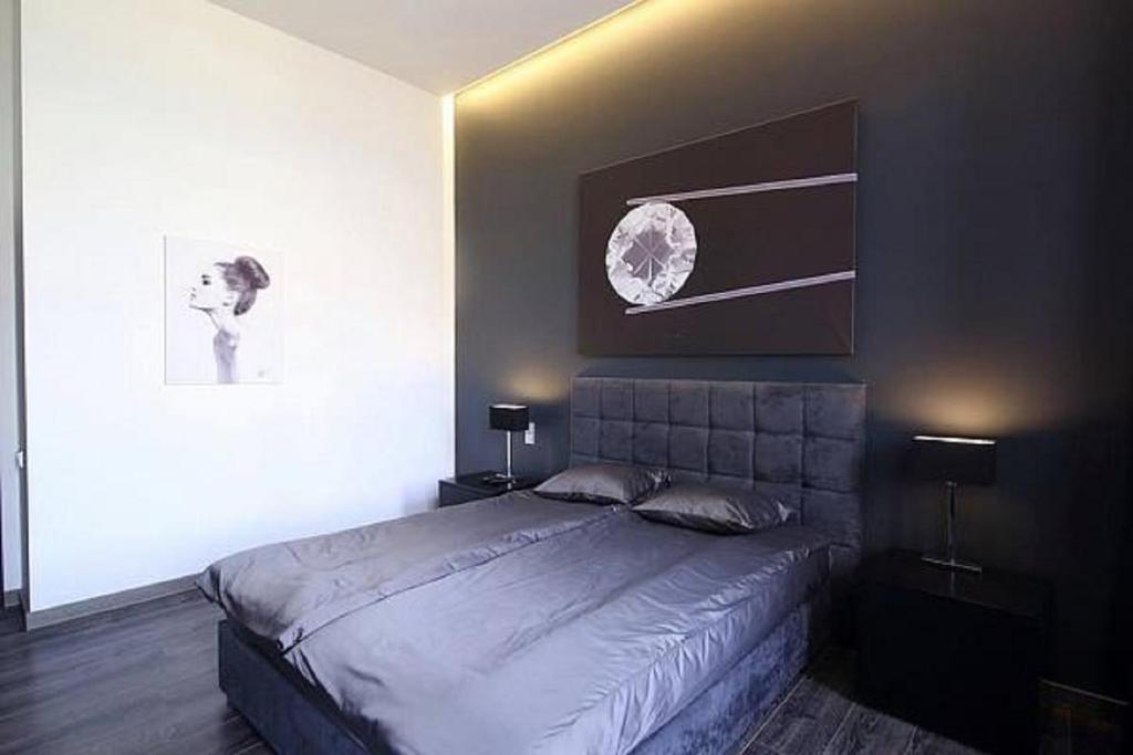 ein Schlafzimmer mit einem Bett und einem Bild an der Wand in der Unterkunft Apartment Ruska Street in Lwiw