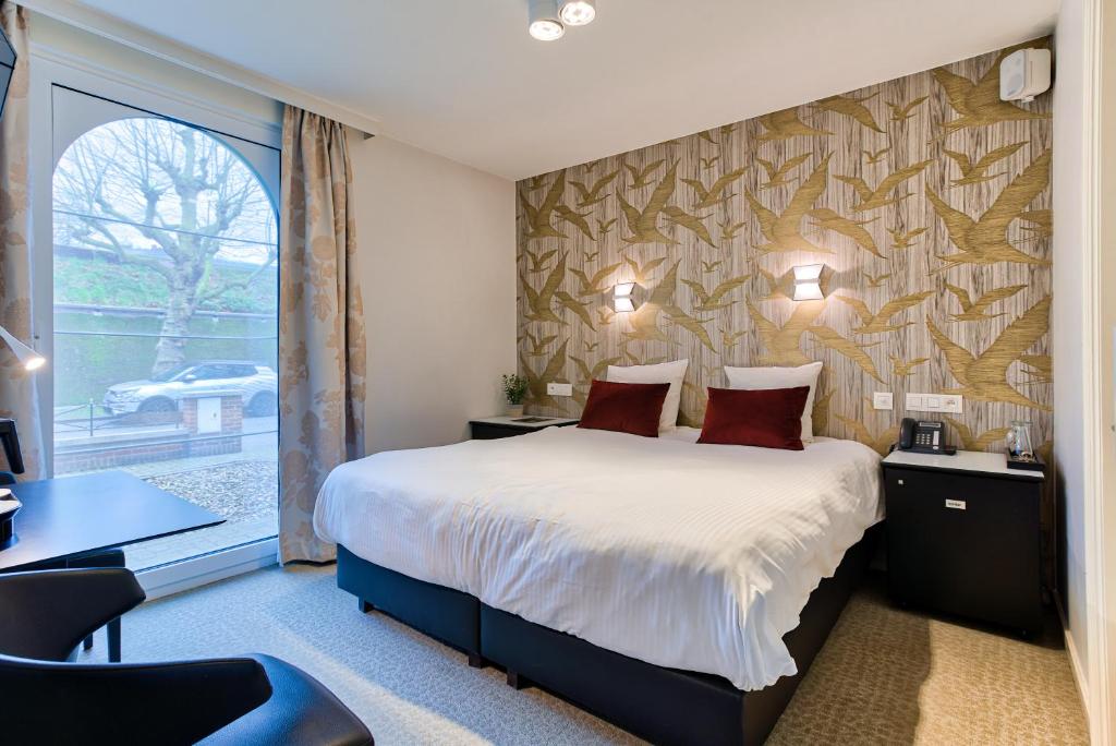 Una habitación de hotel con una cama y una ventana. en Hotel Astoria Gent, en Gante