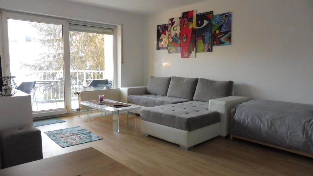 uma sala de estar com um sofá e uma mesa em KEHL Center Schöne 2 Zimmer Wohnung mit Terrasse 60M2 em Kehl am Rhein