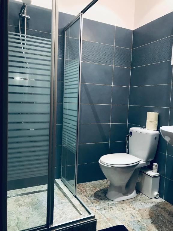 a bathroom with a toilet and a glass shower at The Barts City Center - Self Check-in in Vienna