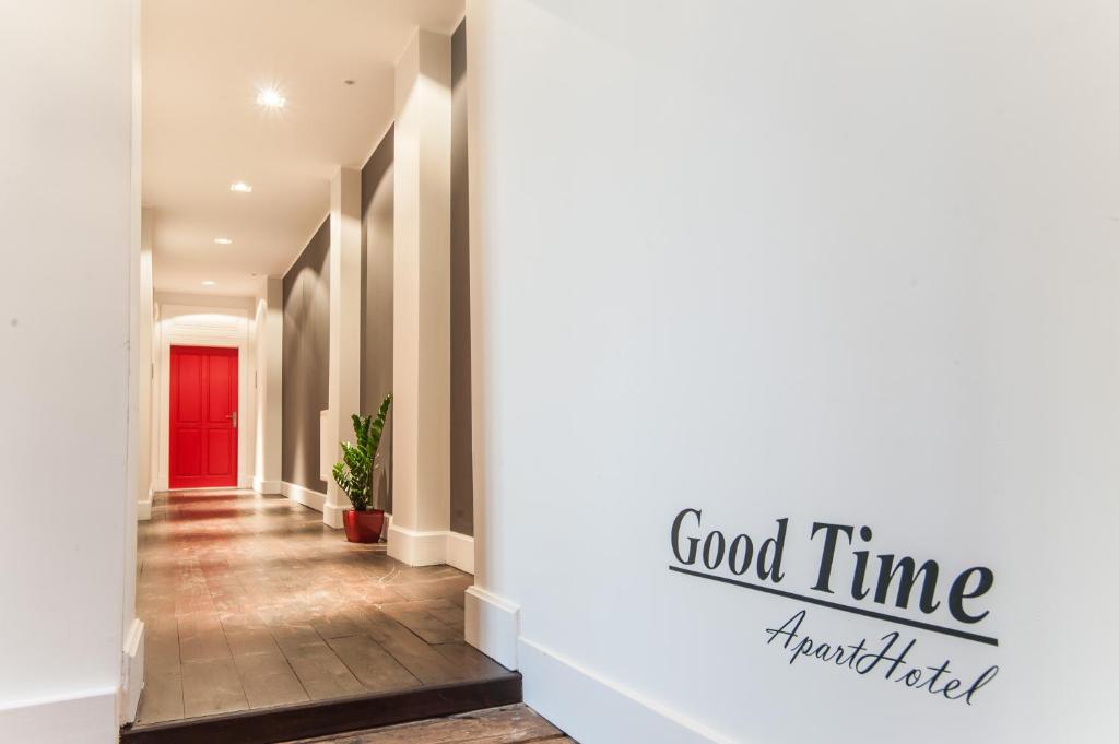 a hallway with a red door and a sign that reads good time marketfield at Good Time Aparthotel in Łódź