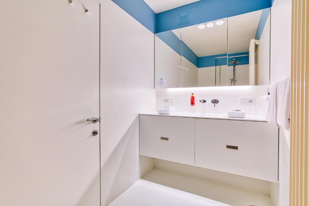 baño blanco con ducha y lavamanos en Hotel Astoria Gent, en Gante