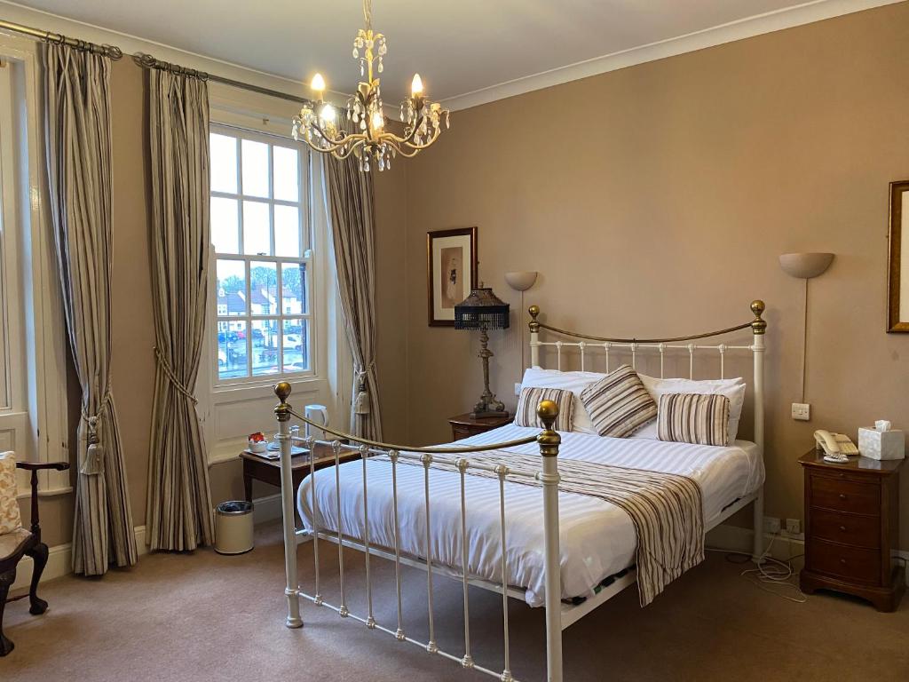 a bedroom with a bed and a chandelier at OYO The Leven in Stokesley