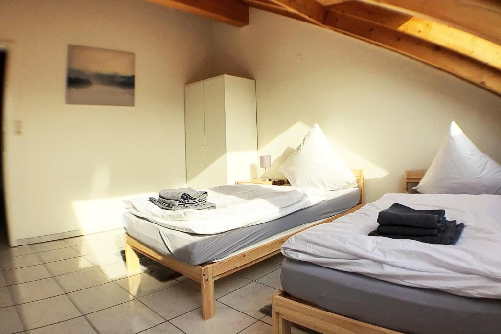 dos camas sentadas una al lado de la otra en una habitación en Workers Apartment- three room apartment with kitchen and wifi, en Büsingen