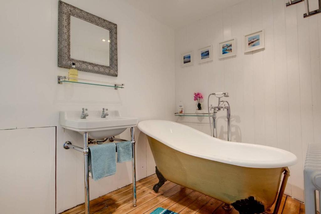 a bathroom with a tub and a sink at Carnegie Library: Austen Apartment 2 bedroom in Mexborough