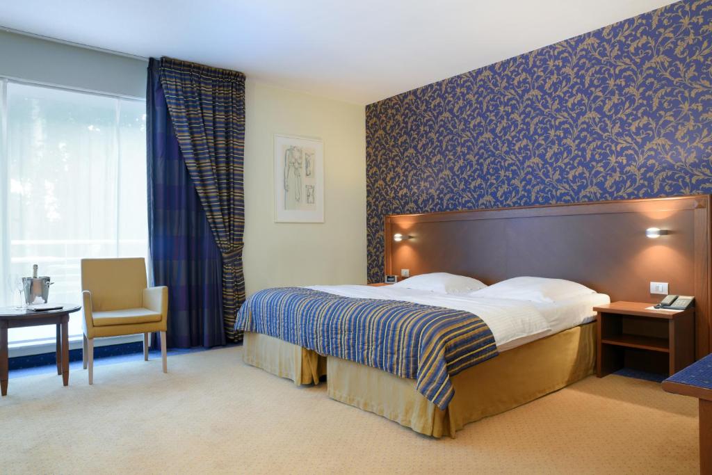 ein Hotelzimmer mit einem Bett und einem Stuhl in der Unterkunft De Watermolen in Kasterlee
