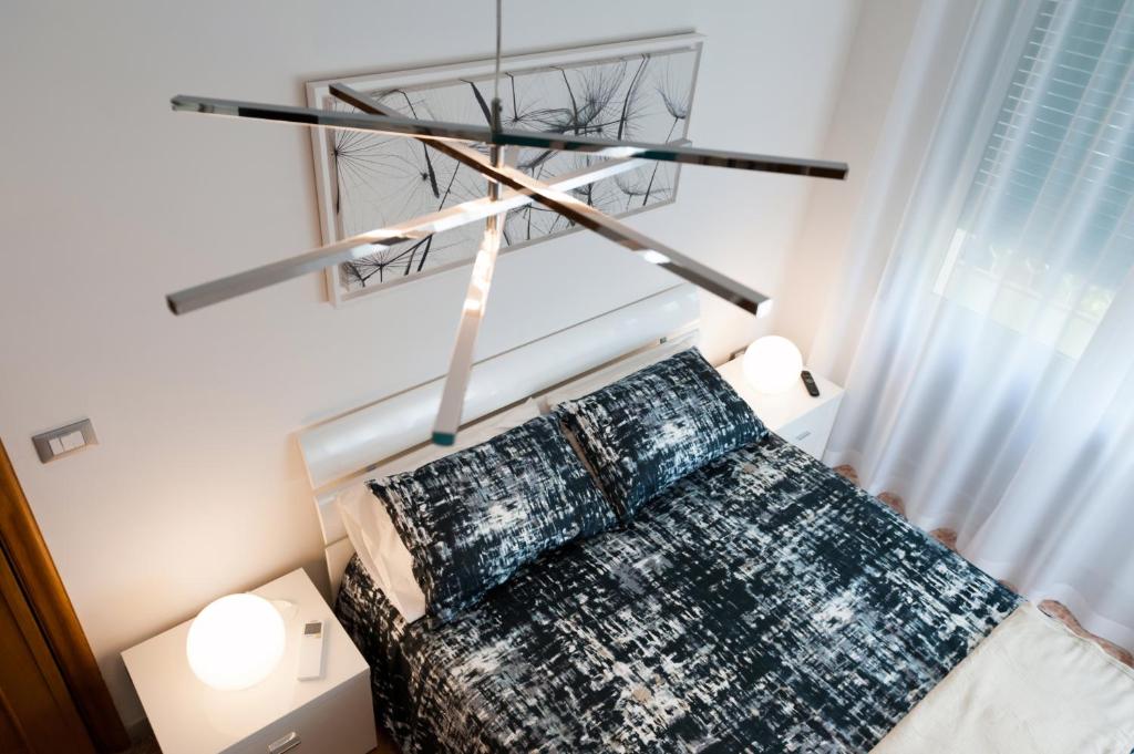 een slaapkamer met een bed met een kroonluchter erboven bij Fly by Suites Pescara in Pescara