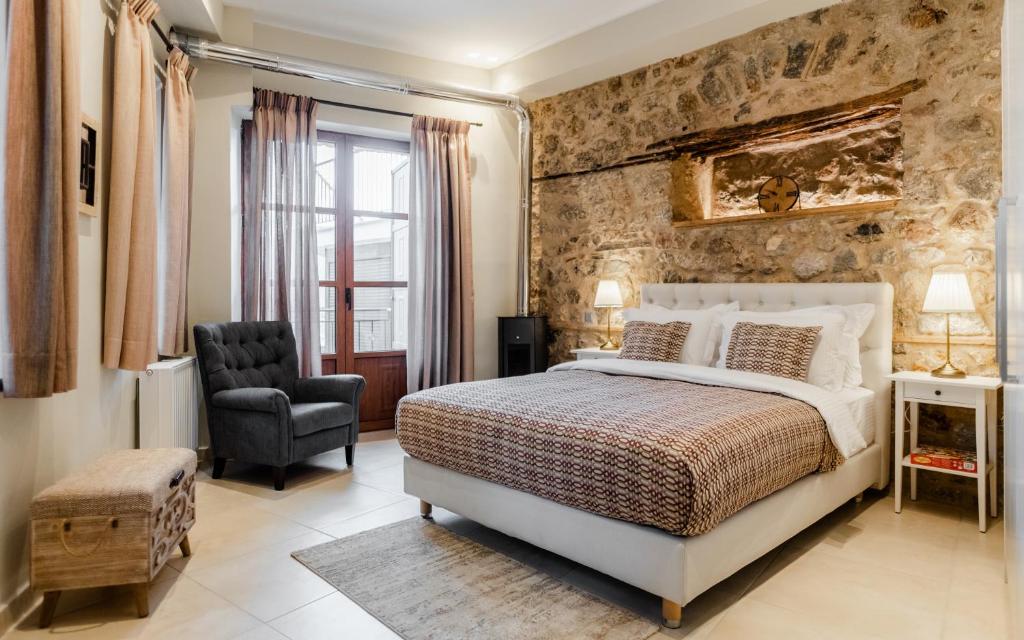 - une chambre avec un lit king-size et une chaise dans l'établissement Aldia Suites Arachova, à Arachova