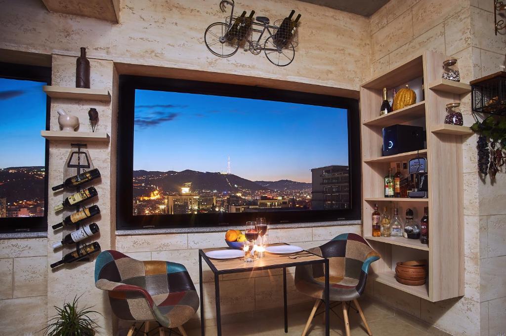Zimmer mit einem großen Fenster mit einem Tisch und Stühlen in der Unterkunft Green Boutique Hotel in Tbilisi City