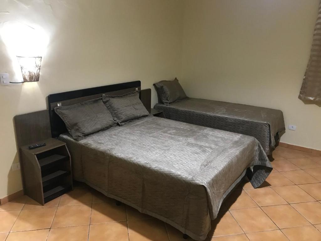 um quarto com duas camas e uma mesa de cabeceira em GA2-Hospedagem Próximo ao Aeroporto de Guarulhos em Guarulhos