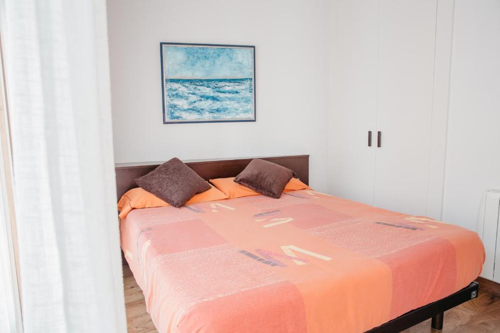 - une chambre avec un lit et une couverture orange dans l'établissement Cal Miquel, à Alpens