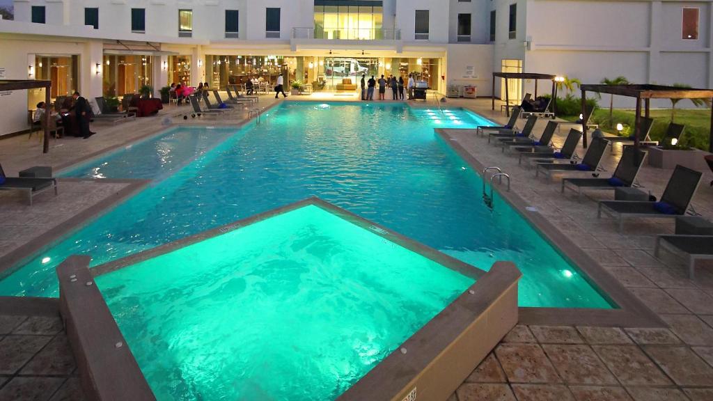 a large swimming pool with chairs in a building at Crowne Plaza Airport by IHG in Tocumen
