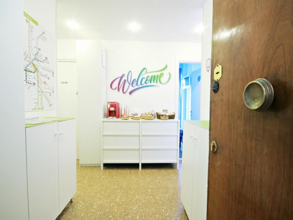 a kitchen with white cabinets and a sign on the wall at Luna D'Est in Rome