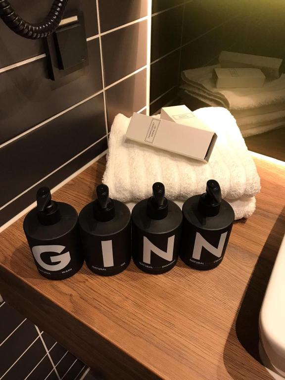 drei schwarze Container mit Buchstaben auf dem Tisch im Badezimmer in der Unterkunft GINN City and Lounge Ravensburg in Ravensburg