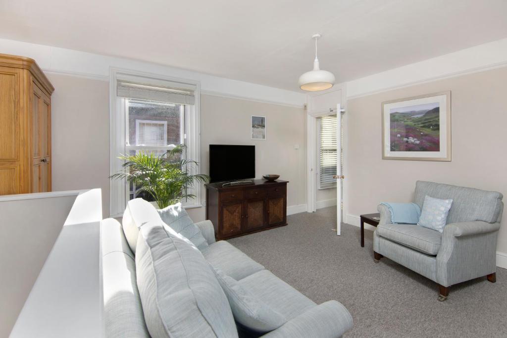 a living room with a white couch and a tv at Salt Lane Apartments in Salisbury