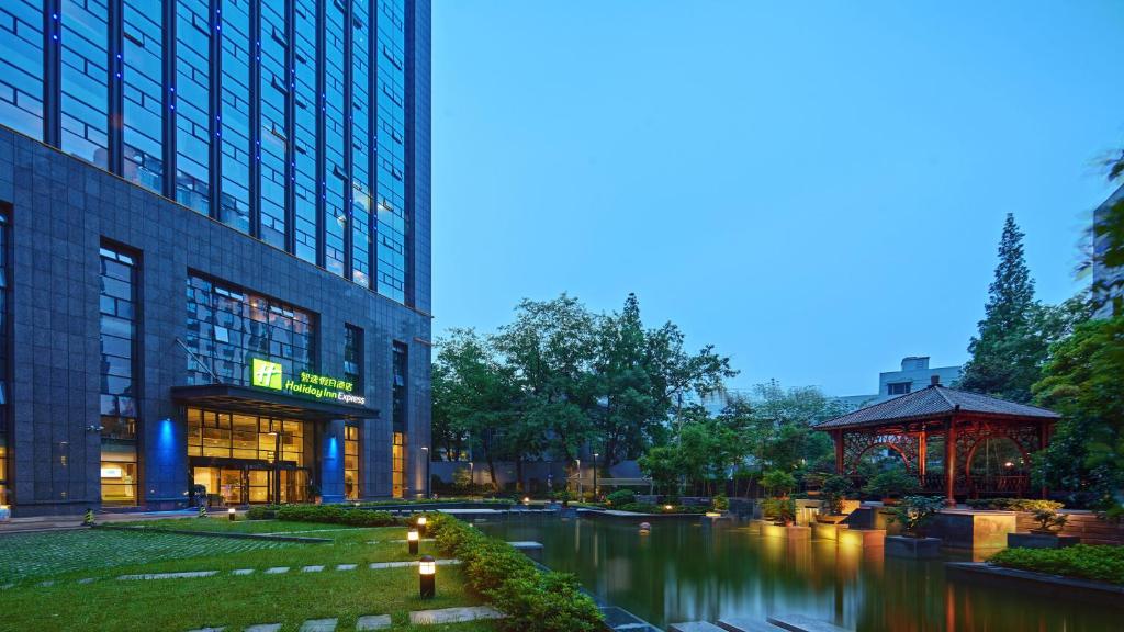 un edificio y un río frente a un edificio en Holiday Inn Express Hangzhou Huanglong, an IHG Hotel, en Hangzhou