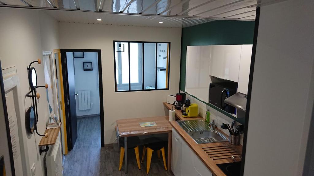Il comprend une petite cuisine avec un évier et un comptoir. dans l'établissement T3 GUYNEMER 1ER ÉTAGE Plage à 80 M Linge de lit fourni, à Les Sables-dʼOlonne