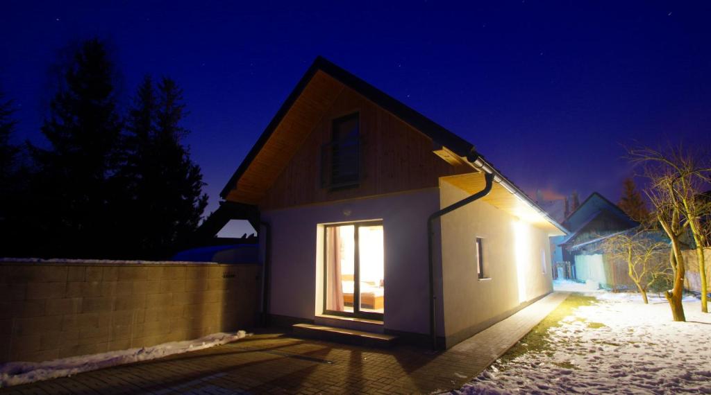 uma pequena casa branca com uma janela à noite em Chalupa Pohoda Demänová em Liptovsky Mikulás-Demänová