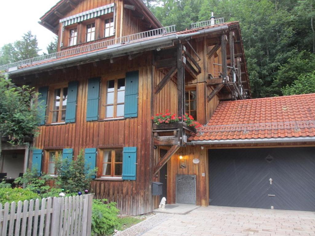 a wooden house with a garage in front of it at Chalet Montfort in Sonthofen