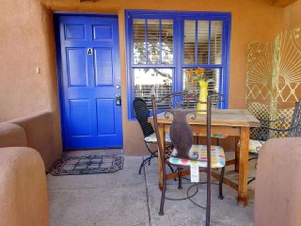 Casas de Guadalupe - Sante Fe Vacation Rentals في سانتا فيه: وجود قطه جالسه على كرسي على طاوله