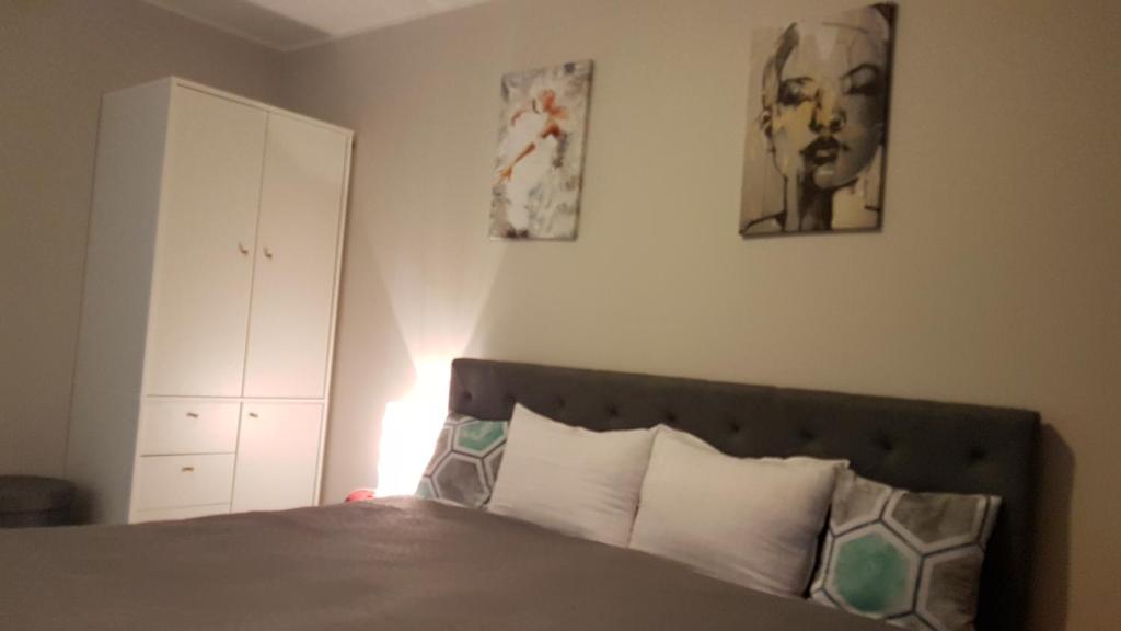 een slaapkamer met een bed en twee foto's aan de muur bij Apartament Świętoszów in Świętoszów