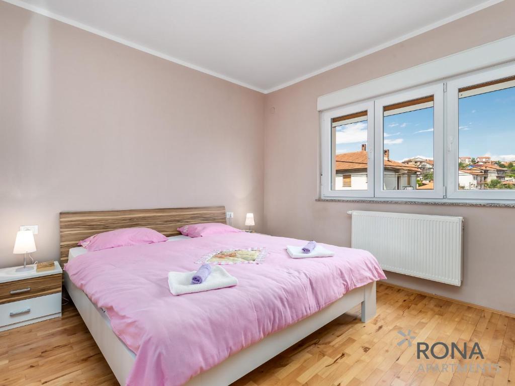 sypialnia z dużym łóżkiem z różową pościelą w obiekcie Rona apartments Smokva w mieście Rijeka