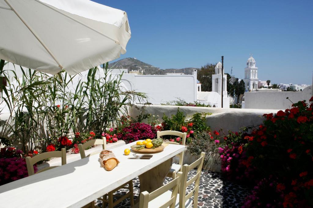 biały stół z talerzem owoców i kwiatów w obiekcie Santorini Heritage Villas w mieście Megalochori