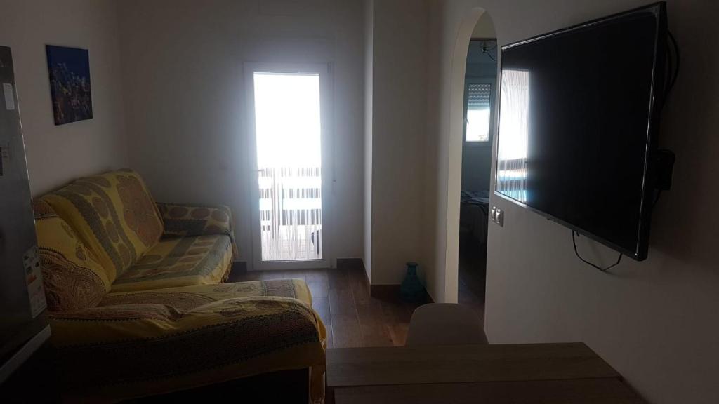 salon z kanapą i telewizorem z płaskim ekranem w obiekcie apartamento el molino con piscina privada w mieście Las Negras