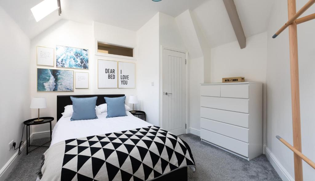 a white bedroom with a black and white bed at Beach View Apartment in Saltburn-by-the-Sea