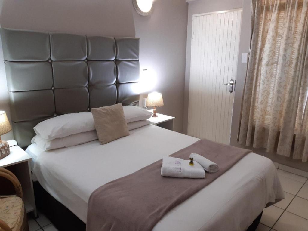 - une chambre avec un grand lit et 2 serviettes dans l'établissement Lavender Lane, à Ladysmith