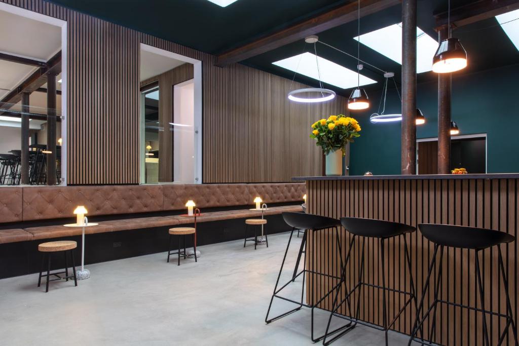 a restaurant with a bar with stools and lights at Sleepcph in Copenhagen