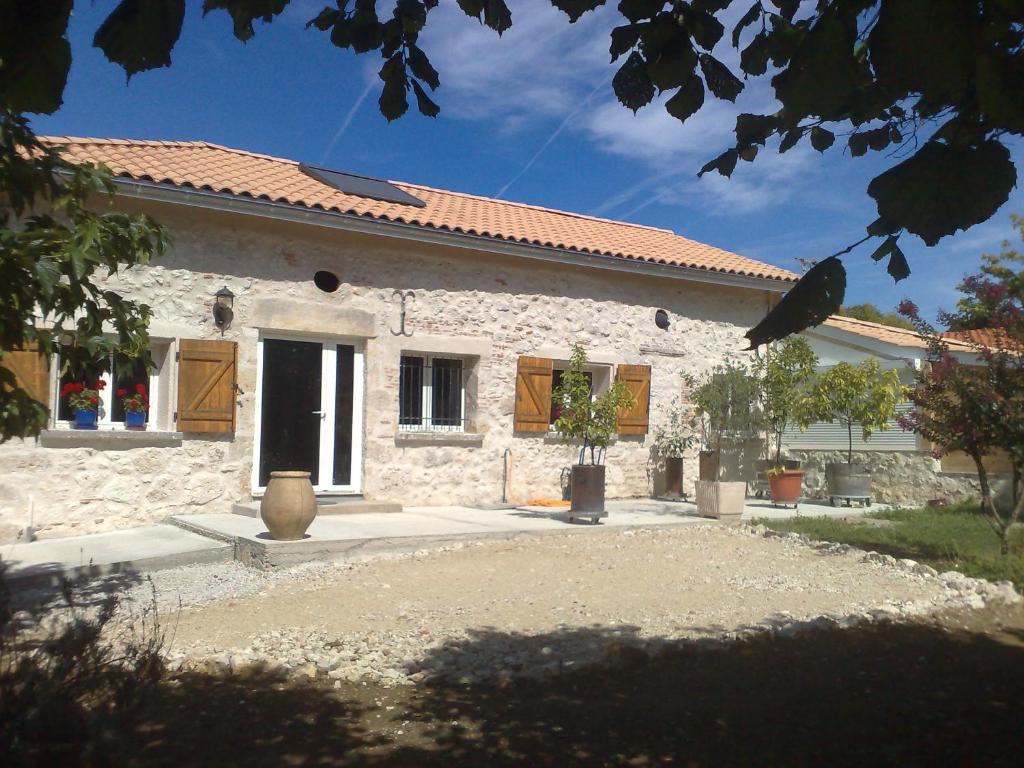 uma casa de pedra branca com um pátio em frente em Halte Mobilité Professionnelle au Mois em Agen