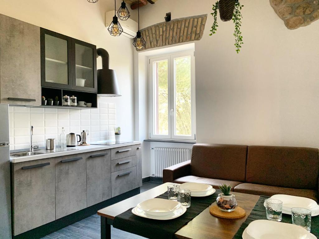 a kitchen and living room with a table and a couch at Abbazia di San Paolo Appartamento Moderno in Rome