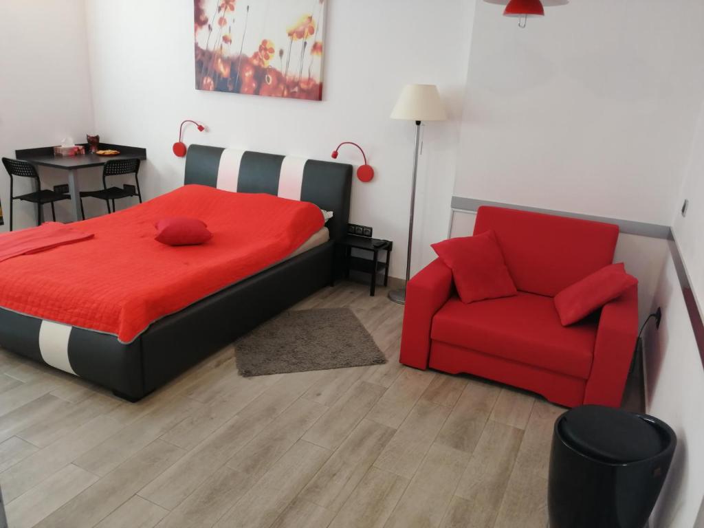 sypialnia z czerwonym łóżkiem i czerwonym krzesłem w obiekcie Apartament Salezego w Warszawie