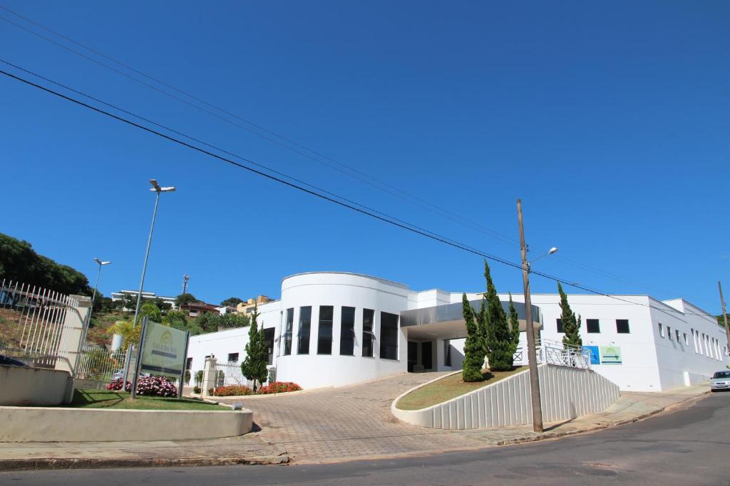 a large white building on a street at Vale do Sol Pousada Hotel in São José do Rio Pardo
