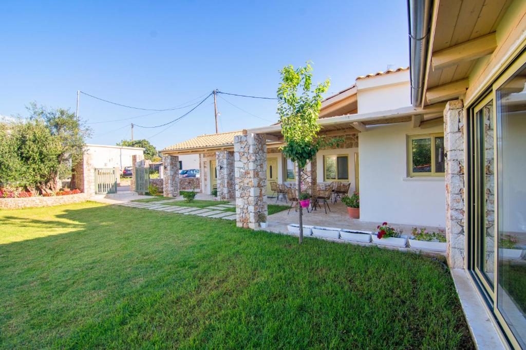 une maison avec une pelouse devant elle dans l'établissement Acrothea Perdika, à Perdika