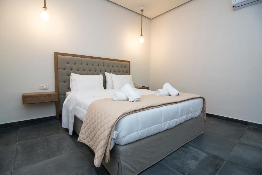 a bedroom with a large bed with two white pillows at Acrothea Perdika in Perdika