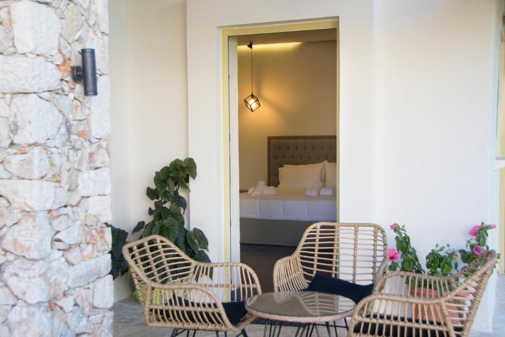 a patio with two chairs and a table and a bed at Acrothea Perdika in Perdika