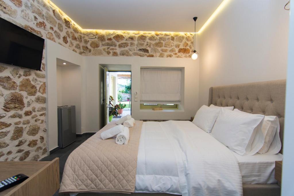 a bedroom with a large bed and a television at Acrothea Perdika in Perdika