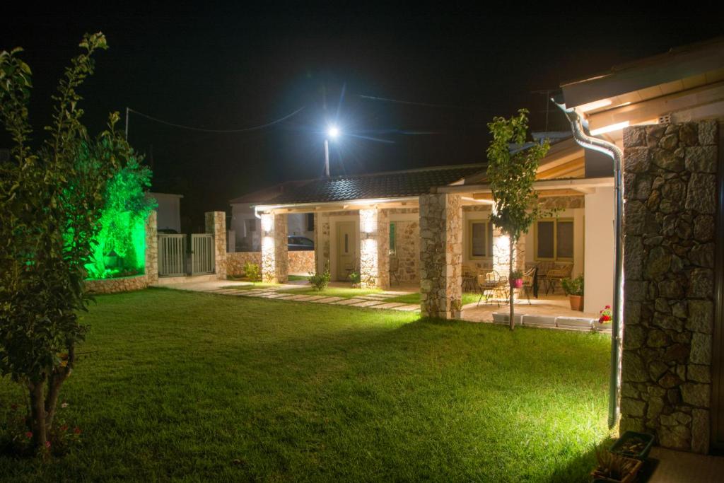 a house with lights on the yard at night at Acrothea Perdika in Perdika