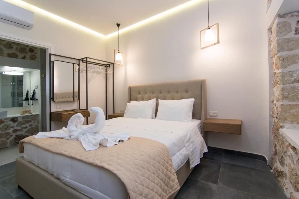 a hotel room with a bed with a swan on it at Acrothea Perdika in Perdika