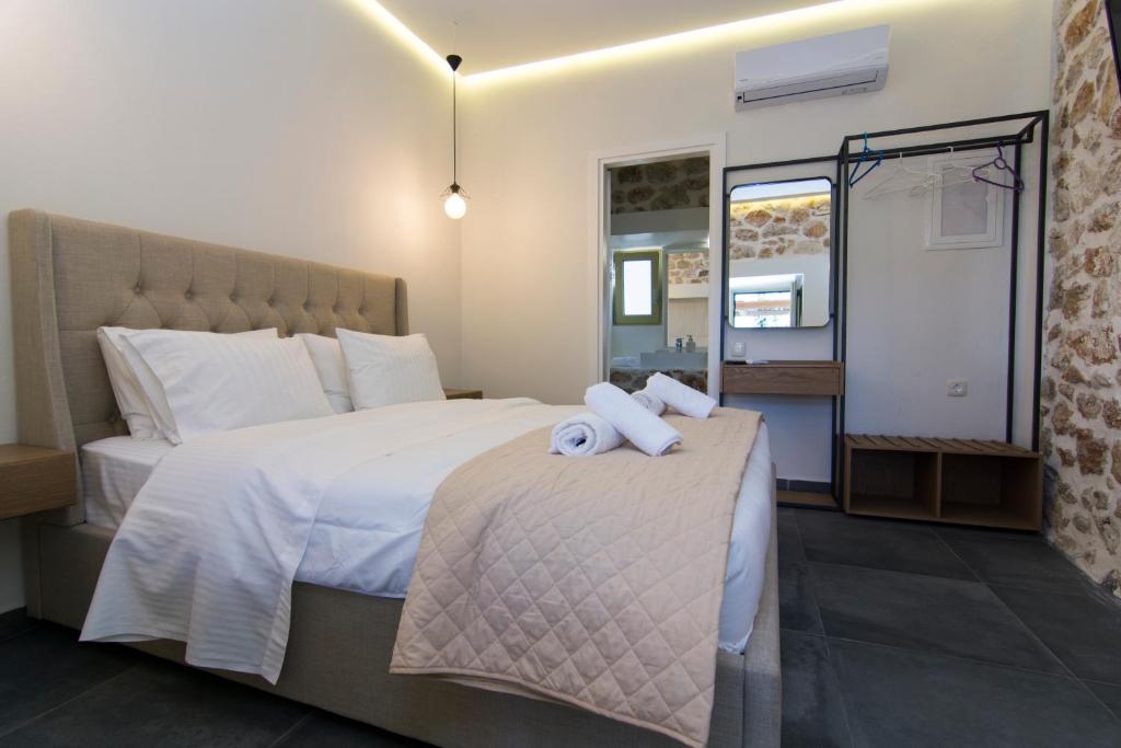a hotel room with a bed with two towels on it at Acrothea Perdika in Perdika