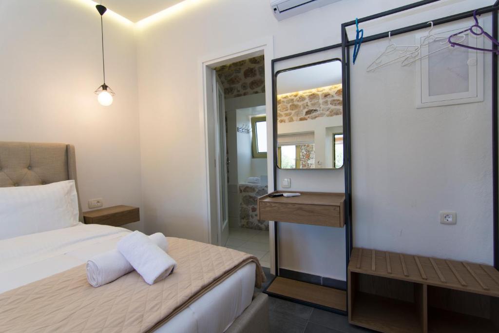 a small bedroom with a bed and a mirror at Acrothea Perdika in Perdika