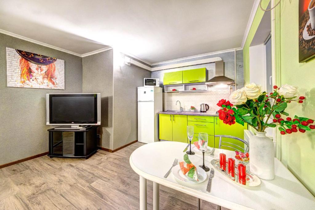 a small kitchen with a white table and a tv at Apartments on Klovsky descent 20 in Kyiv