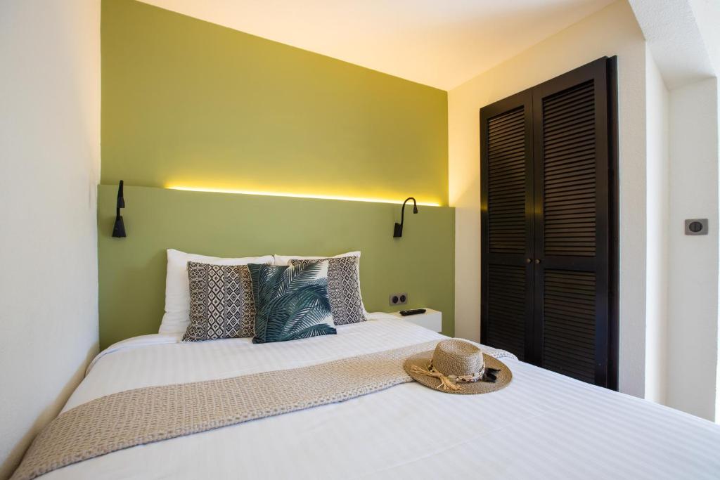 a bedroom with a bed with a hat on it at Centr'Hotel in Marigot