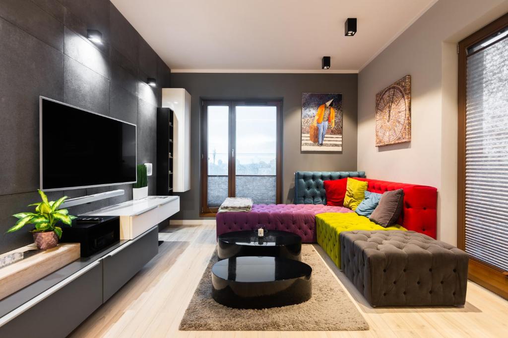 a living room with a couch and a tv at Elegant Business Accommodation with Parking in Krakow