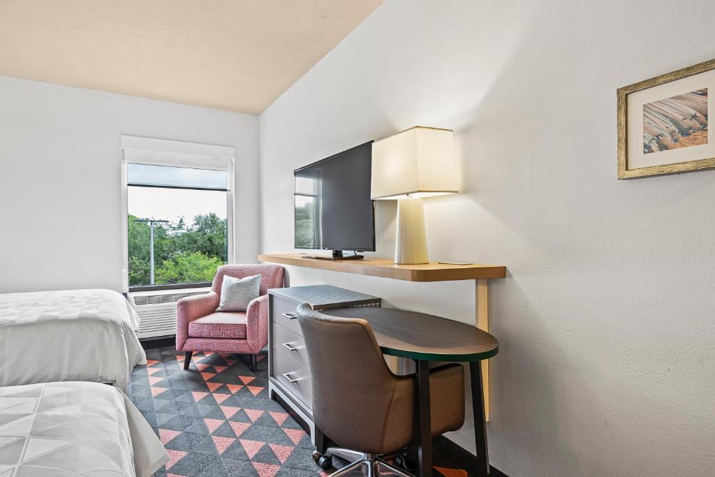 a hotel room with a desk with a computer and a chair at Holiday Inn - St. Petersburg West by IHG in St Petersburg