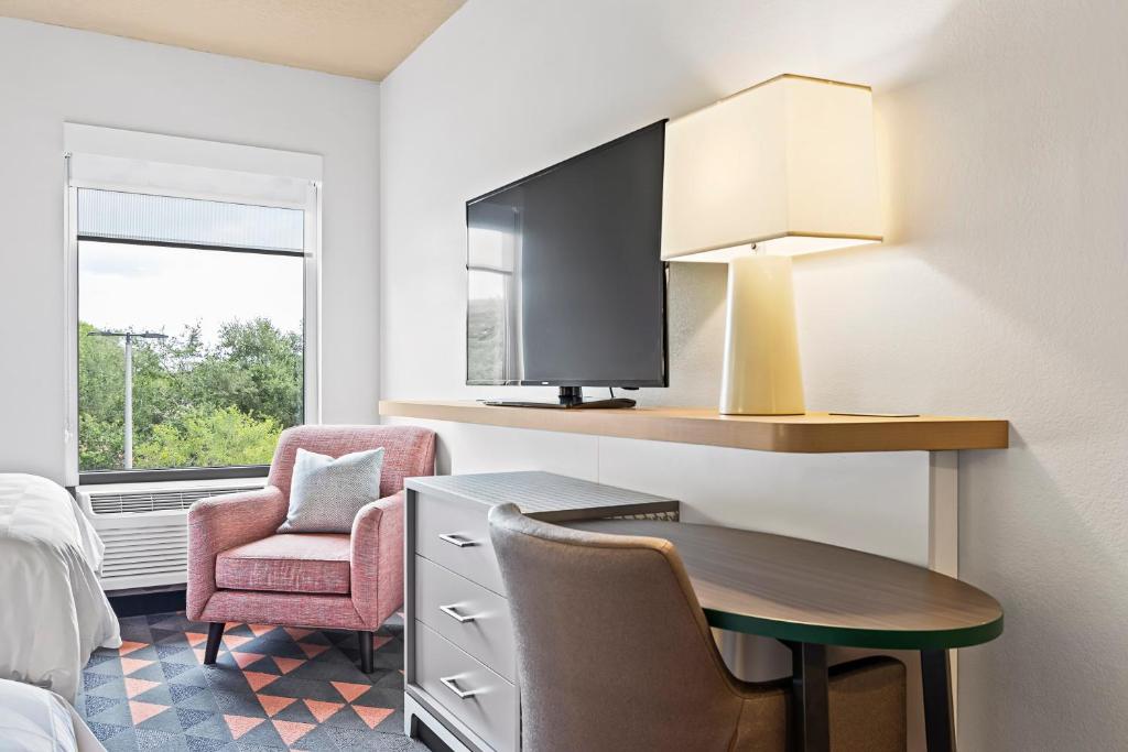 a hotel room with a desk and a chair and a tv at Holiday Inn - St. Petersburg West by IHG in St Petersburg