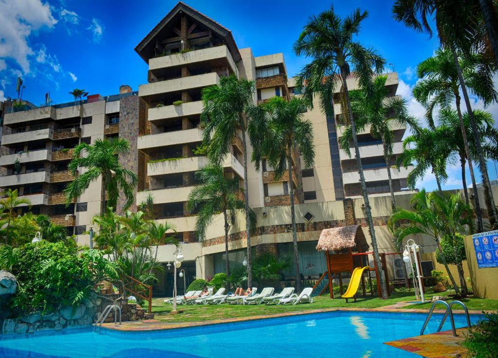 a hotel with a swimming pool in front of a building at Apart Hotel TOBOROCHI in Santa Cruz de la Sierra