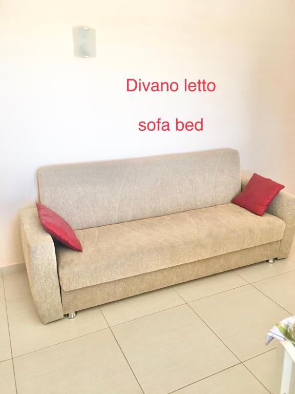 kanapę z 2 czerwonymi poduszkami w pokoju w obiekcie L'attico di Greta,Etna house w mieście Mascalucia